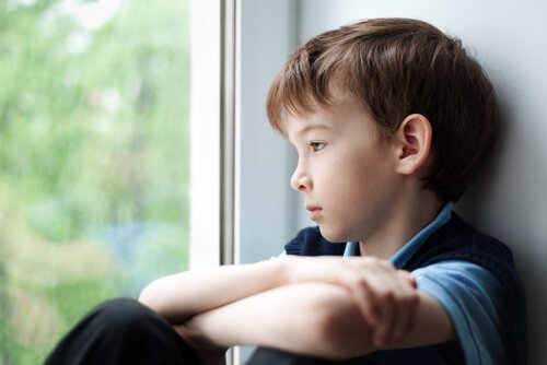Kiusaamisen terveysvaikutukset: poika katsoo ikkunasta