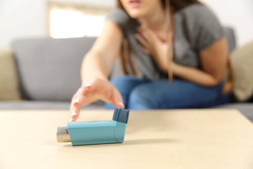 Nainen kurkottaa astmapiippuun.
