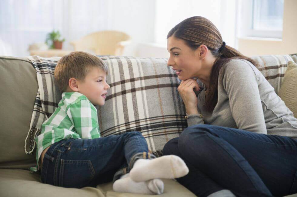 Poika ja äiti keskustelevat sohvalla