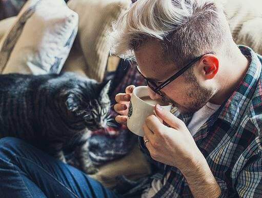 Mies pienessä tilassa kissan kanssa.